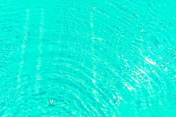 Surface of shining swimming pool water ripple in futuristic green toning. Perfect as a background for summer, vacation, calmness, serenity or any other idea.