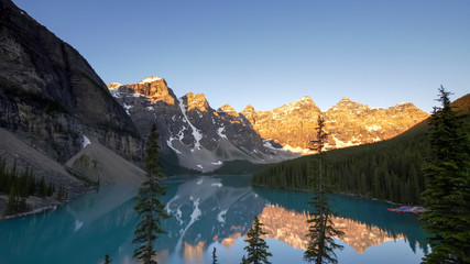 Fototapeta premium sunrise shot of moraine lake at pine trees in canada