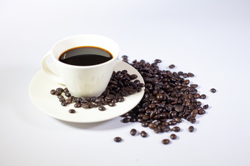 A cup of hot coffee with coffee beans, Black coffee isolated, Roasted coffee beans in bottles, and spoon, white background
