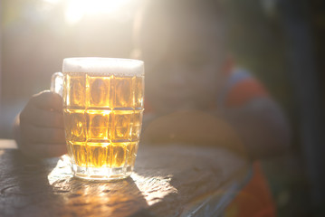 Concept of Withdrawal Symptoms from alcohol or Alcoholic diseases.Hand with a glass of beer on wood.