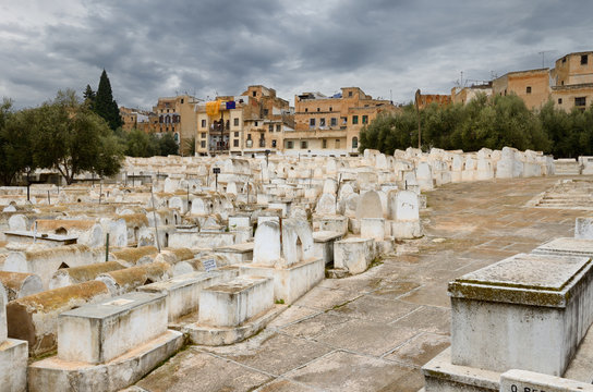 Above ground white tombs in the Mellah Jewish cemetery on a cloudy day in Fes Morocco