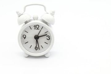 A white retro alarm clock isolated on white background. Alarm clock used to awaken people from their night's sleep or short naps.