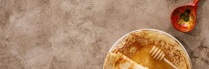 Delicious homemade pancakes with honey on a textural background. Top view, close-up. Traditional holiday celebration concept. Russian translation wide and happy Shrovetide Maslenitsa.