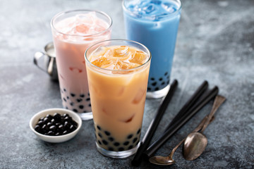 Variety of milk bubble tea in tall glasses, strawberry, butterfly tea and black