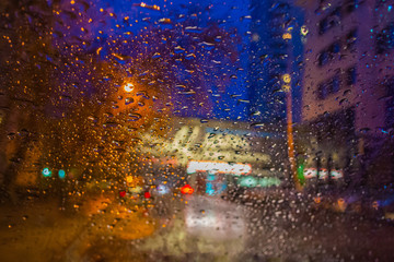 Defocused Blurred photo. Drops on the glass. View of the street