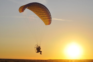 Paraglider soars in the sky. Sunset.