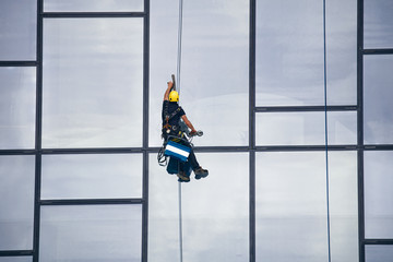 Window Cleaner at Working. Window cleaner, in the suspension system. Industrial mountaineering.