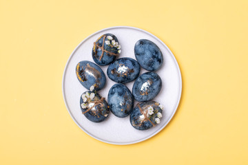 Flat Lay of Golden Easter Eggs in row placed on yellow background. Easter background or easter concept.