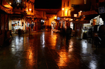 Obraz premium Cafes at Bab Boujeloud Blue Gate on a wet night in Fes el Bali Medina Morocco