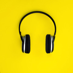 Wireless headphones on a yellow background. Minimalism.