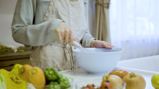 キッチンで調理をする若い女性の手元