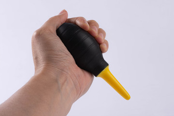 rubber air blower in hand Oliver White background, accessory for dust removing