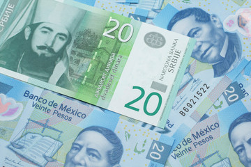 Fototapeta premium A close up of a green and white, twenty Serbian dinar bank note on a background of Mexican twenty peso bank notes