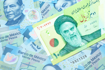 Fototapeta premium A macro image of a green ten thousand rial bank note from Iran on a bed of Mexican twenty peso bank notes close up