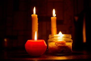 Candle on dark background. Candle in low key. Candle flame at night closeup
