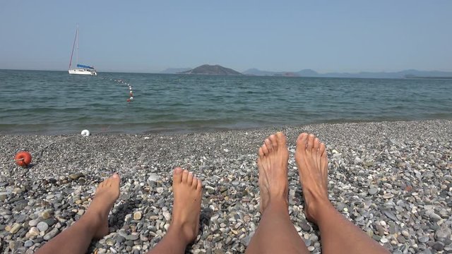 Fethiye, Turkey - 16th of May 2019: 4K Child and adult's feet on the beach