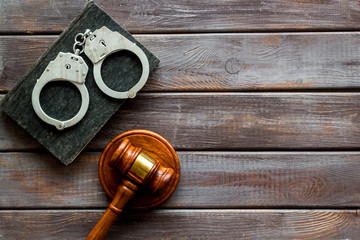 Arrest concept. Handcuffs near judge gavel on dark wooden background top-down copy space