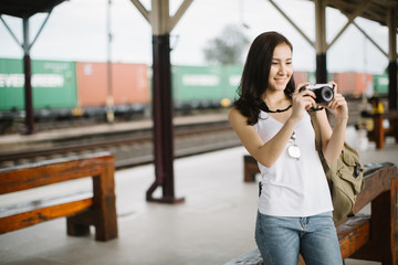 Outdoor summer smiling lifestyle portrait of pretty young woman having fun in the city with camera travel photo of photographer Making pictures