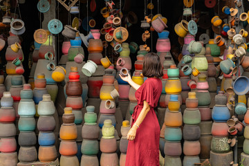 Young brunette woman looking at clay pot