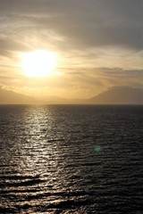 evocative image of sunset over the sea with headland silhouette in the background