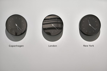 Three dark wall clocks with different time