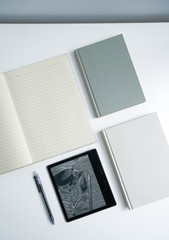 Fototapeta premium Books and notebooks and kindle eBooks on white desktop
