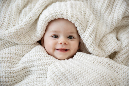 Close Up Of Happy Baby Wrapped In Blanket