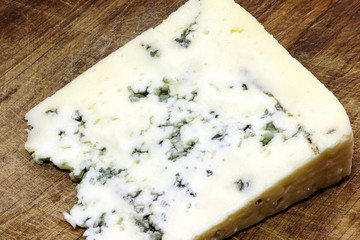 Moldy cheese on a cutting board. Blue cheese.