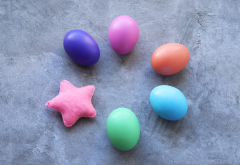 Easter colored eggs, laid in a circle and a homemade star made of pink felt, as an element of decor. selective focus.