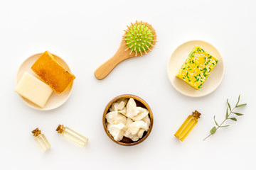 Coconut, argan and jojoba oil for hair. Set with brush on white background top-down