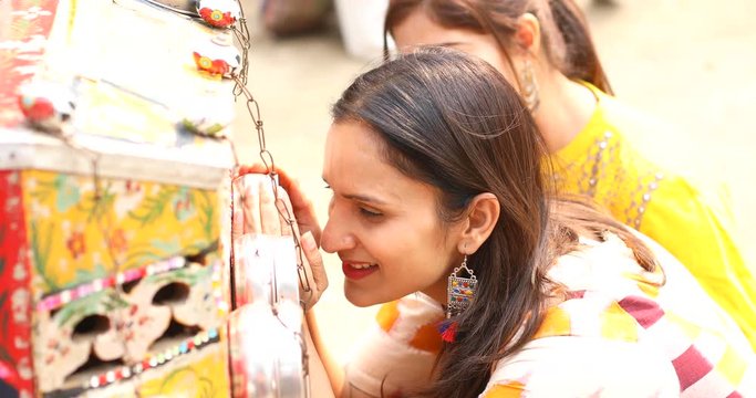 Women looking into bioscope at Surajkund Mela