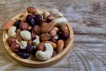 Mix of nuts and dried fruits at weathered wooden background