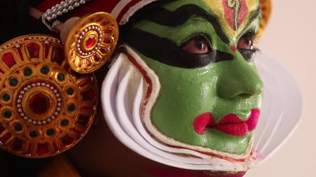 Close up of a Kathakali dancer giving expressions with his eyes. 
