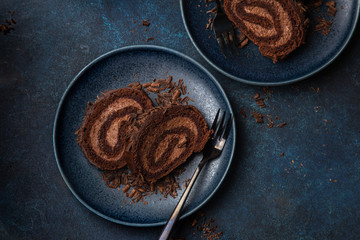 slices of delicious chocolate roll cake on blue plate