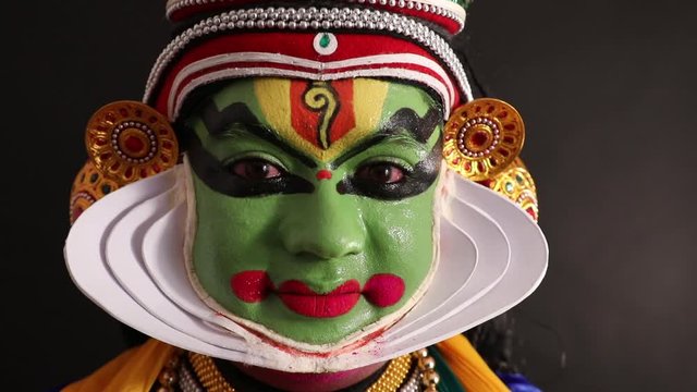 Close up face of a Kathakali dancer smiling. 