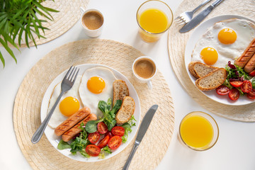 breakfast with fried eggs, sausages, fresh vegetables, coffee and orange juice on white table - obrazy, fototapety, plakaty