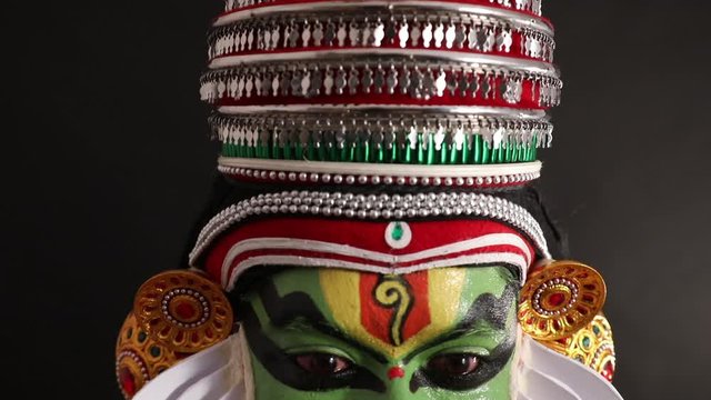 Close up face of a Kathakali dancer smiling. 