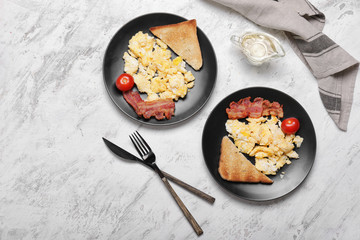Tasty scrambled eggs with bacon and toasted bread on white background