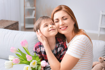 Little boy greeting his mother at home