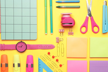 Set of school supplies with clock on color background