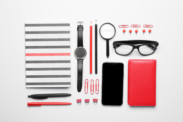 Set of school supplies with mobile phone on white background