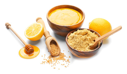 Bowl of tasty honey mustard sauce with ingredients on white background