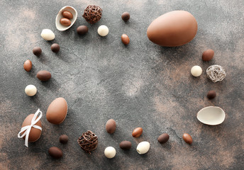 Frame made of tasty chocolate Easter eggs on grey background