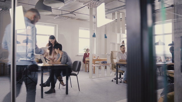 Multiethnic team working in modern trendy office. Happy young smiling creative millennials work in light coworking 4K.
