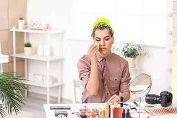 Transgender woman applying makeup at home