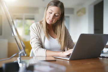 Portrait of woman at home conected with laptop