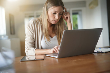 Portrait of woman at home conected with laptop