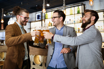 Business people drink beer after work in pub. Businessmen enjoy a beer.