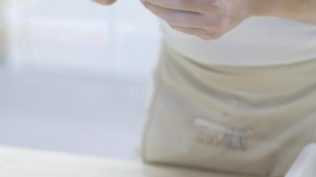 Woman chef or cook making handmade organic healthy Italian pasta called tortello or raviolo, traditional Italian stuffed pasta. Folding the dough and shaping it. Meat stuffed pasta.