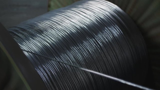 Aluminum wire is wound on the large coil in the manufacture of electric cable at the factory.